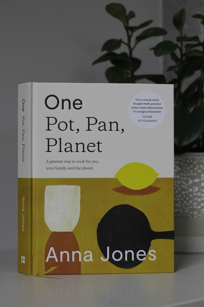 Image shows the front cover of a book titled One: Pot, Pan Planet by Anna Jones, with simplistic artwork of a cast iron skillet, a lemon, and a glass.