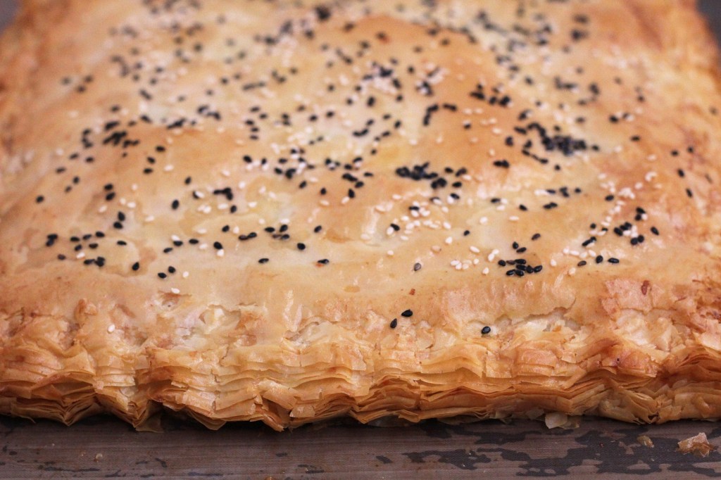 A close of the edges of golden flaky phyllo pie.