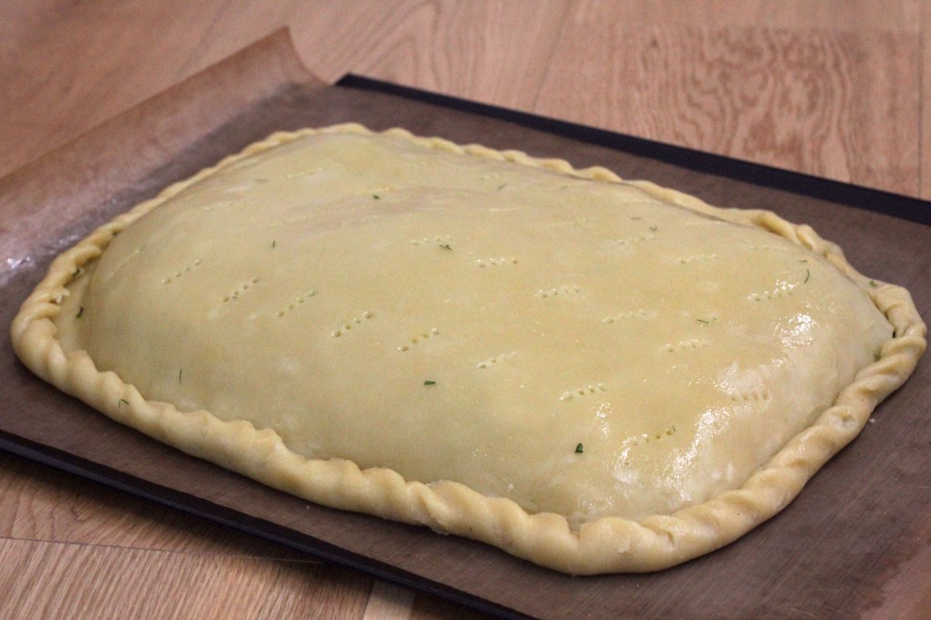 Image shows a freeform pie encased in pastry and hand-crimped at the edges.