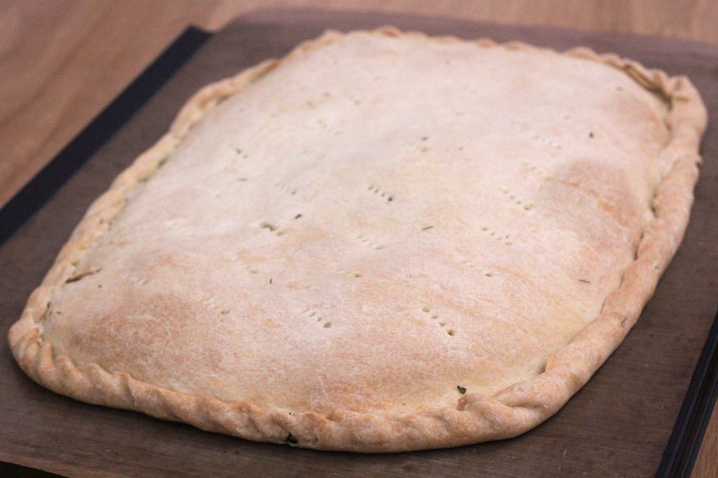 Image shows a pale-coloured freeform pie baked on a baking tray.